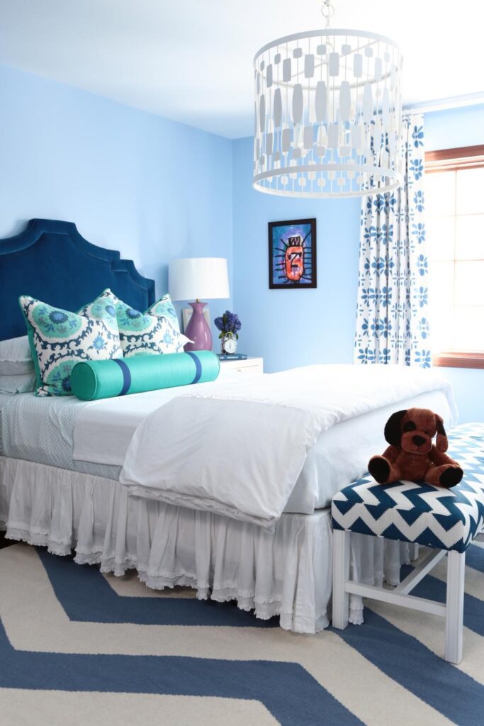 A light blue color wall with royal color bed.