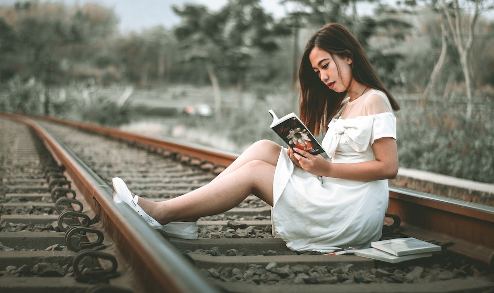 A girl sitting and reading alone
